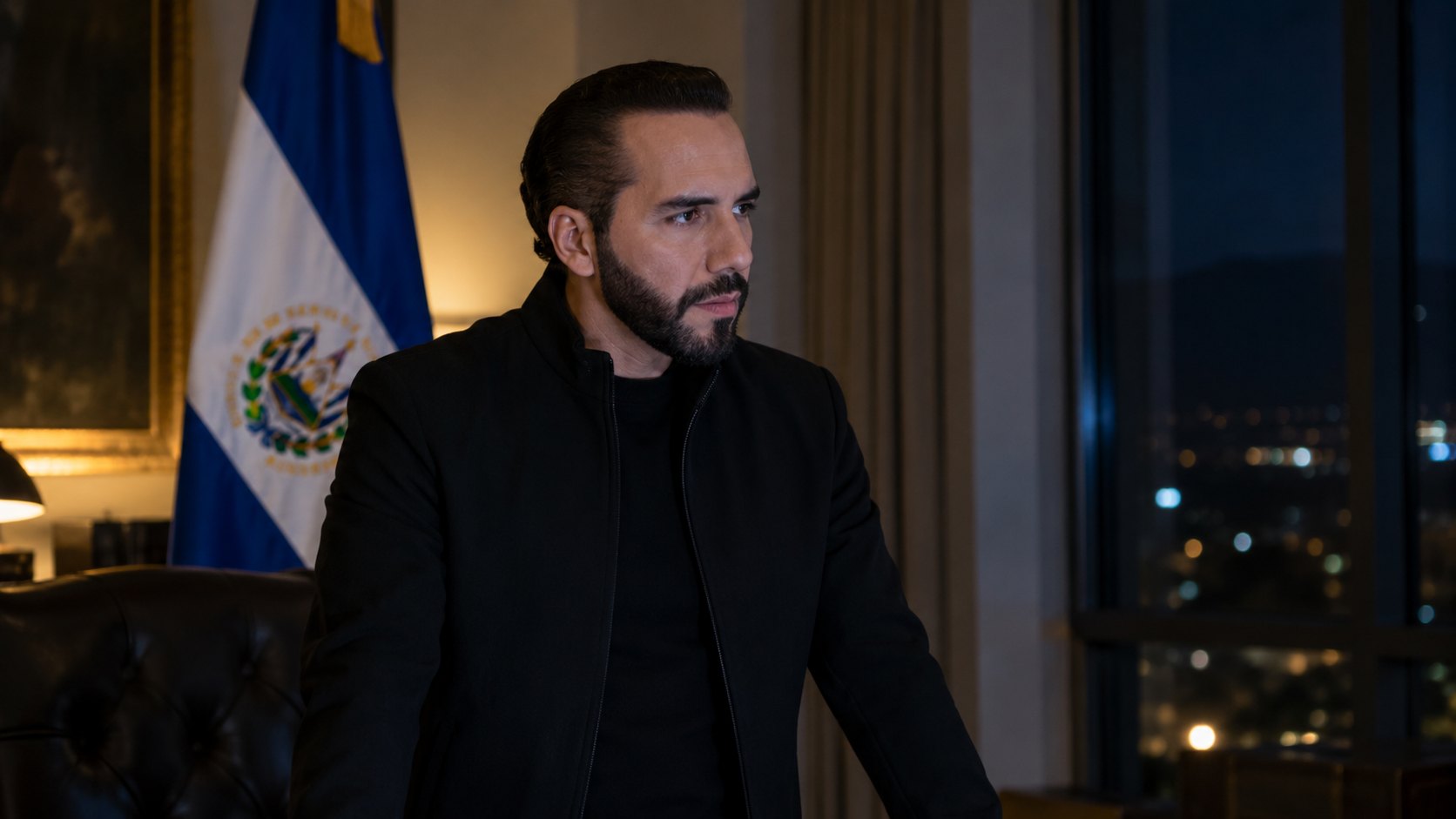 Ilustración editorial generada con IA: Nayib Bukele, presidente de El Salvador, de pie y serio en un despacho de noche, con la bandera salvadoreña detrás y la ciudad iluminada por la ventana; composición conceptual, no es una fotografía real.