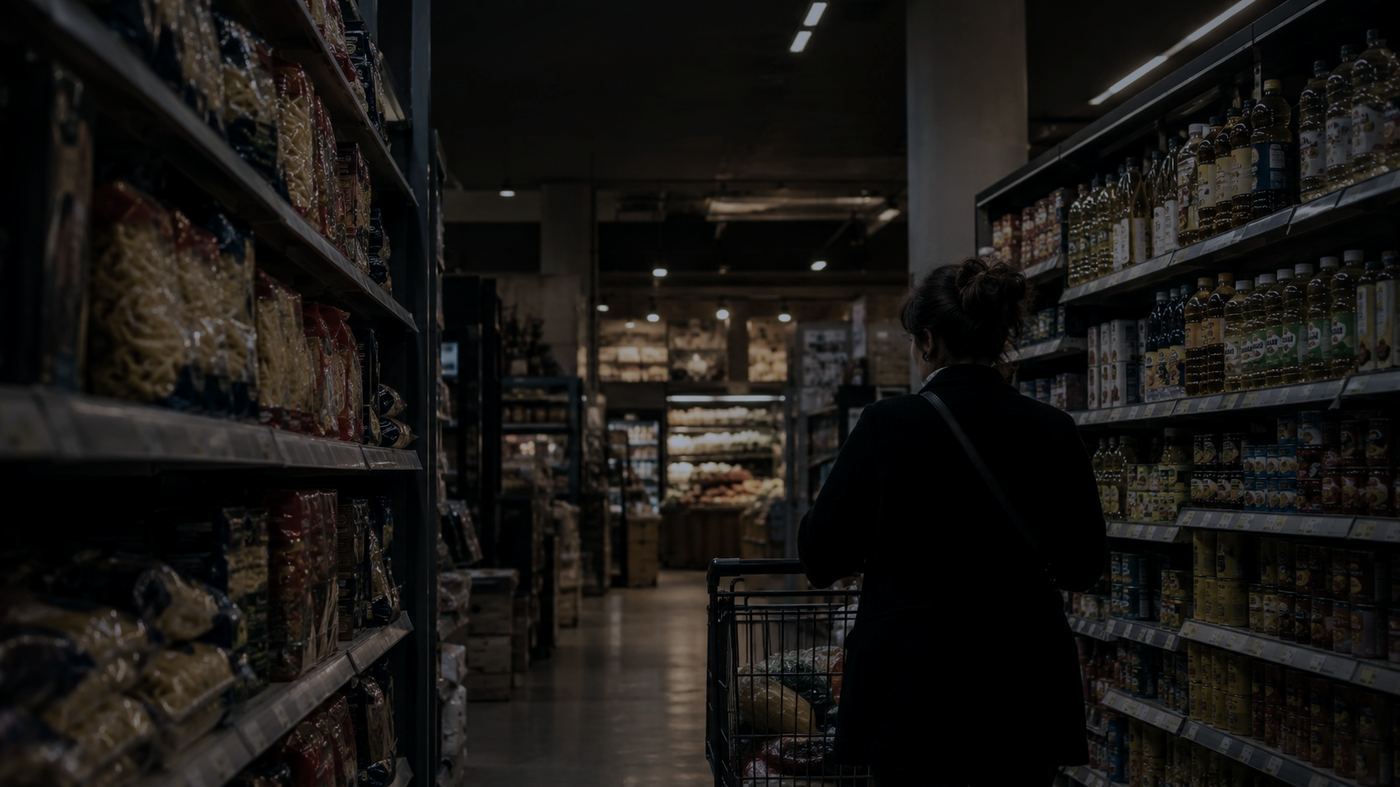 Persona haciendo compras en un supermercado de Buenos Aires, con carrito y góndolas de productos de primera necesidad