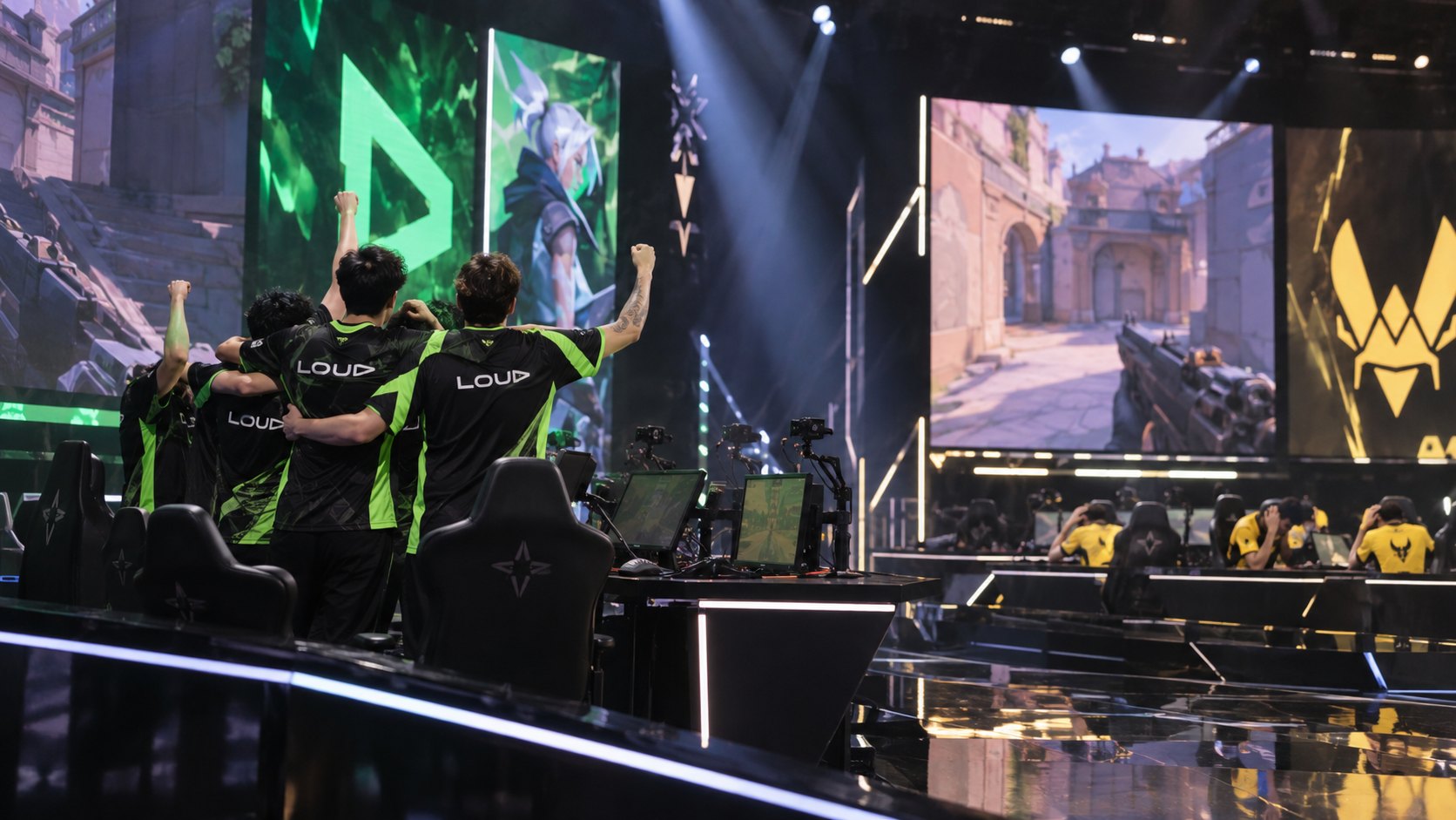 Ilustración editorial generada con IA: de espaldas, jugadores con camisetas negras y verdes con el wordmark LOUD celebran abrazados y con los brazos en alto en el escenario de una arena de e-sports, mientras del otro lado jugadores con camisetas amarillas de Vitality permanecen sentados en sus puestos, bajo pantallas gigantes con VALORANT; composición conceptual, no es una fotografía del partido ni de los jugadores reales.