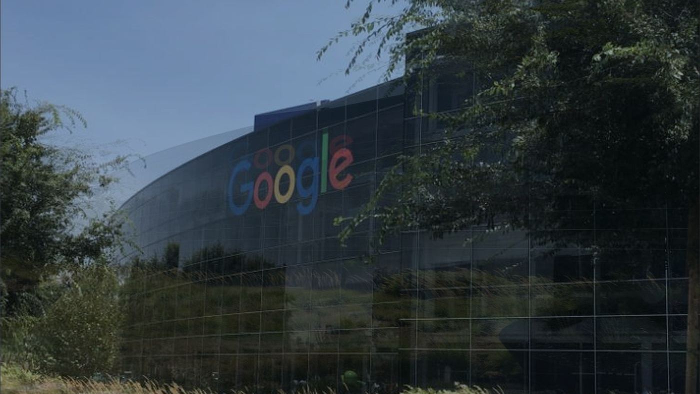 Fachada curva de vidrio del Googleplex, la sede central de Google en Mountain View, California, con el logo de la empresa