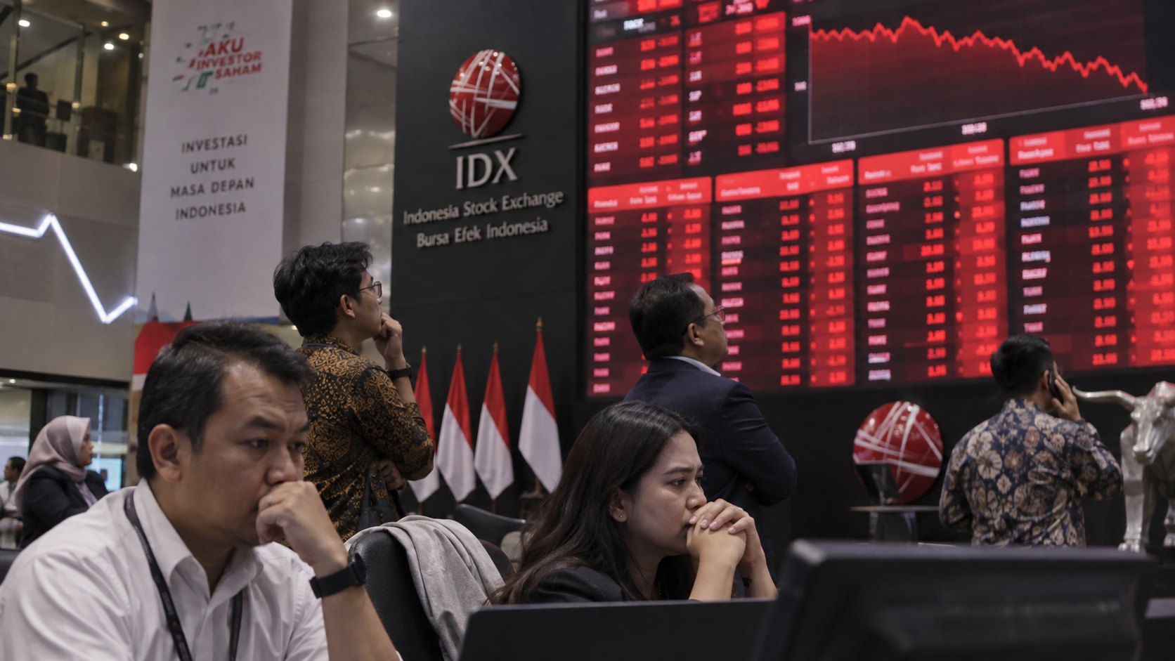 Ilustración editorial generada con IA: el hall de la Bolsa de Indonesia (IDX) en Yakarta, con su logo y una pantalla de cotizaciones en rojo, mientras operadores e inversores observan preocupados junto a banderas de Indonesia; composición conceptual, no es una fotografía de la jornada.