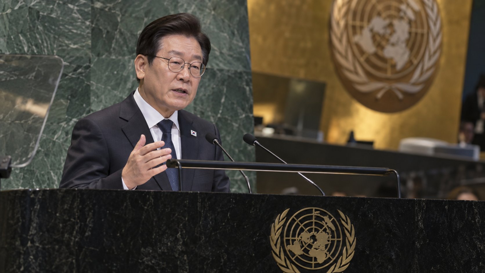 Ilustración editorial generada con IA: Lee Jae-myung habla desde el estrado de la Asamblea General de las Naciones Unidas; no es una fotografía del discurso.