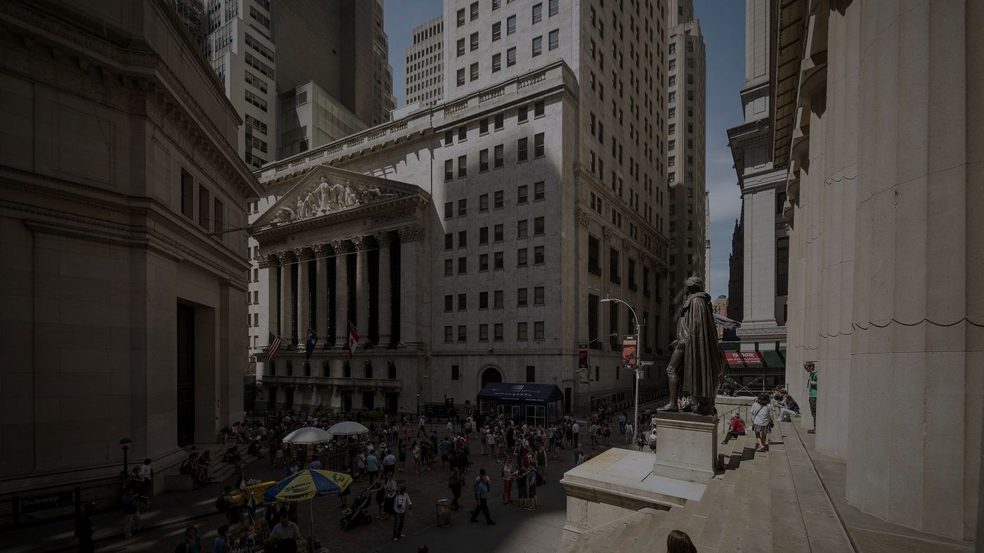 Fachada neoclásica de la Bolsa de Nueva York (NYSE) en la intersección de Wall Street y Broad Street, con la estatua de George Washington en primer plano