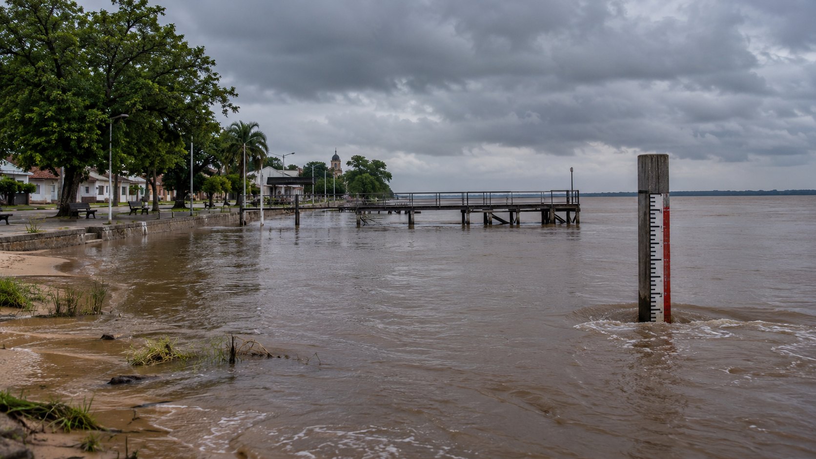 Ilustración editorial generada con IA: la costanera de un pueblo ribereño del Litoral con el río Paraná crecido cubriendo la playa y una escala hidrométrica parcialmente sumergida bajo un cielo de tormenta; no es una fotografía de una localidad real.