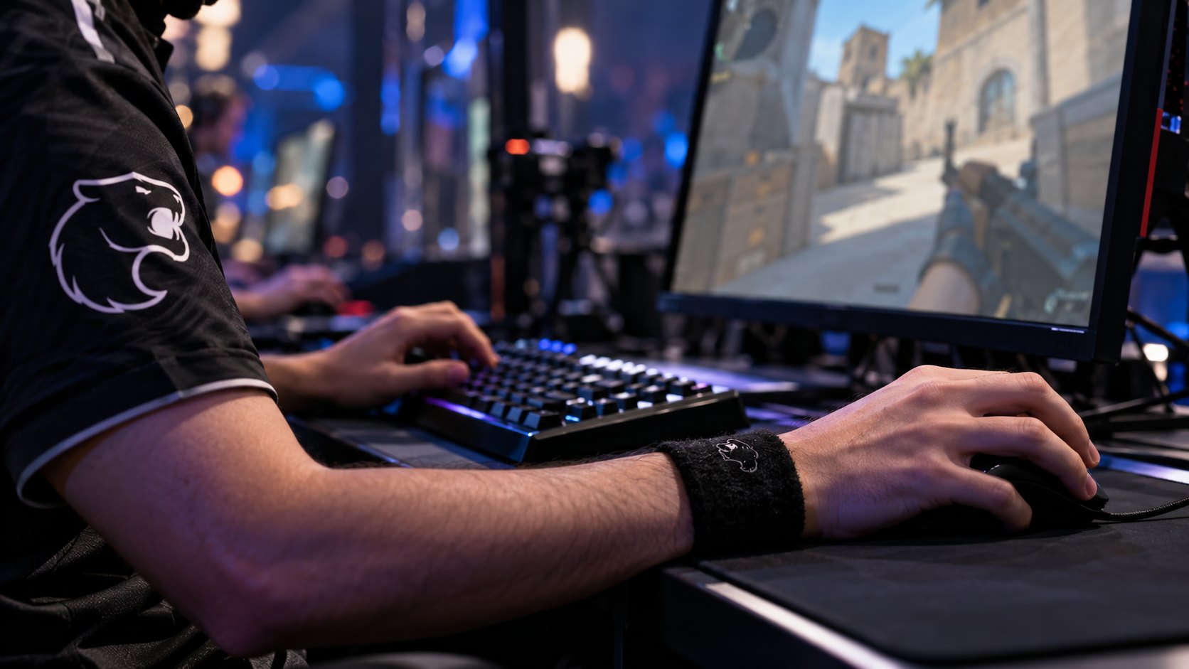 Ilustración editorial generada con IA: primer plano de las manos de un jugador con camiseta negra de FURIA sobre un teclado y un mouse en la cabina de un torneo de Counter-Strike 2; composición conceptual, no es una fotografía de la final.