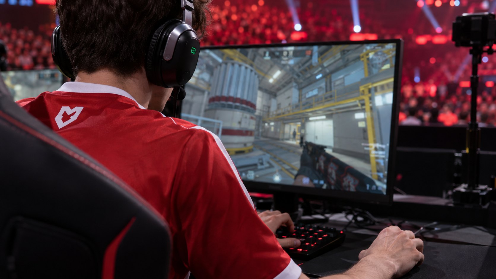 Ilustración editorial generada con IA: un jugador con la camiseta roja de MOUZ, visto por detrás del hombro, con auriculares y las manos sobre el teclado y el mouse, frente a un monitor con el mapa Nuke de Counter-Strike 2; composición conceptual, no es una fotografía del partido.