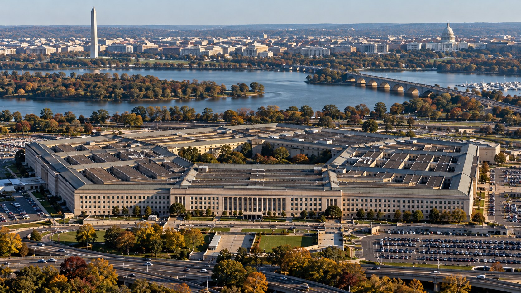 Ilustración editorial generada con IA: vista aérea del Pentágono en Arlington, Virginia, en una mañana de otoño, con el río Potomac, el monumento a Washington y la cúpula del Capitolio al fondo; composición conceptual, no es una fotografía del día del anuncio.
