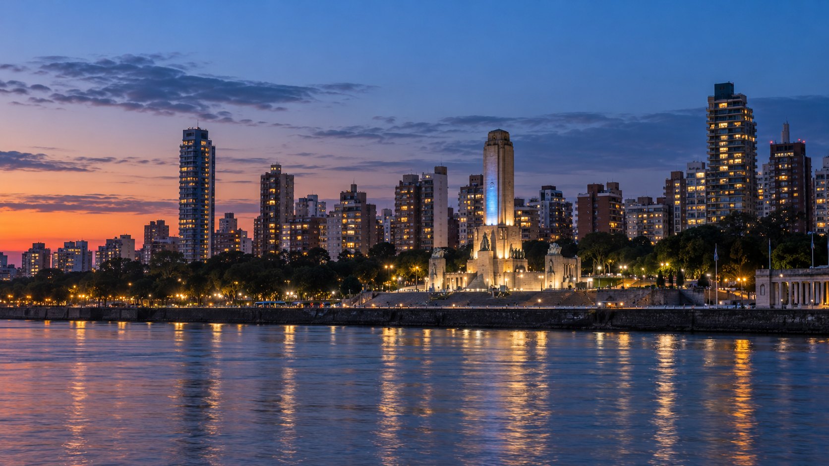 Ilustración editorial generada con IA: la costanera de Rosario al anochecer, con el Monumento a la Bandera iluminado, el río Paraná en primer plano y edificios con ventanas encendidas; composición conceptual.